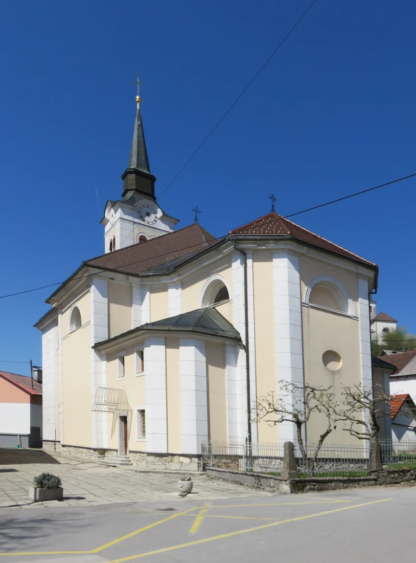 Bočni pogled na cerkev Rožnovenske Matere božje v Gorenjem Logatcu z zvonikom, april 2022