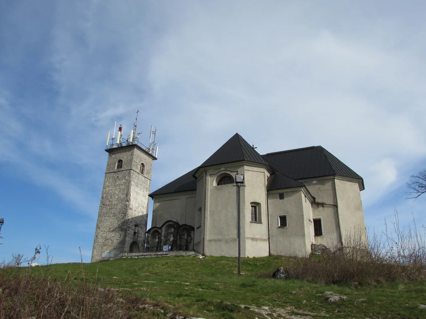 Cerkev sv. Križa na Križni gori z ločenim zvonikom in izstopajočo stransko kapelo
