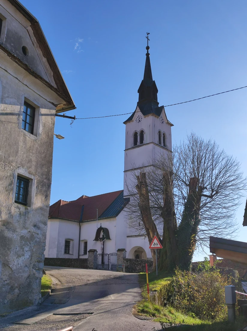 Cerkev sv. Martina na Uncu z zvonikom, stranskim stavbnim delom in vhodom skozi obzidje.
