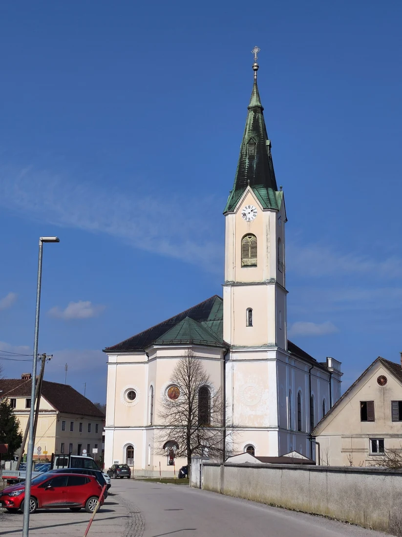 Cerkev sv. Pavla na Vrhniki z visokim zvonikom in uro, pogled marca 2023