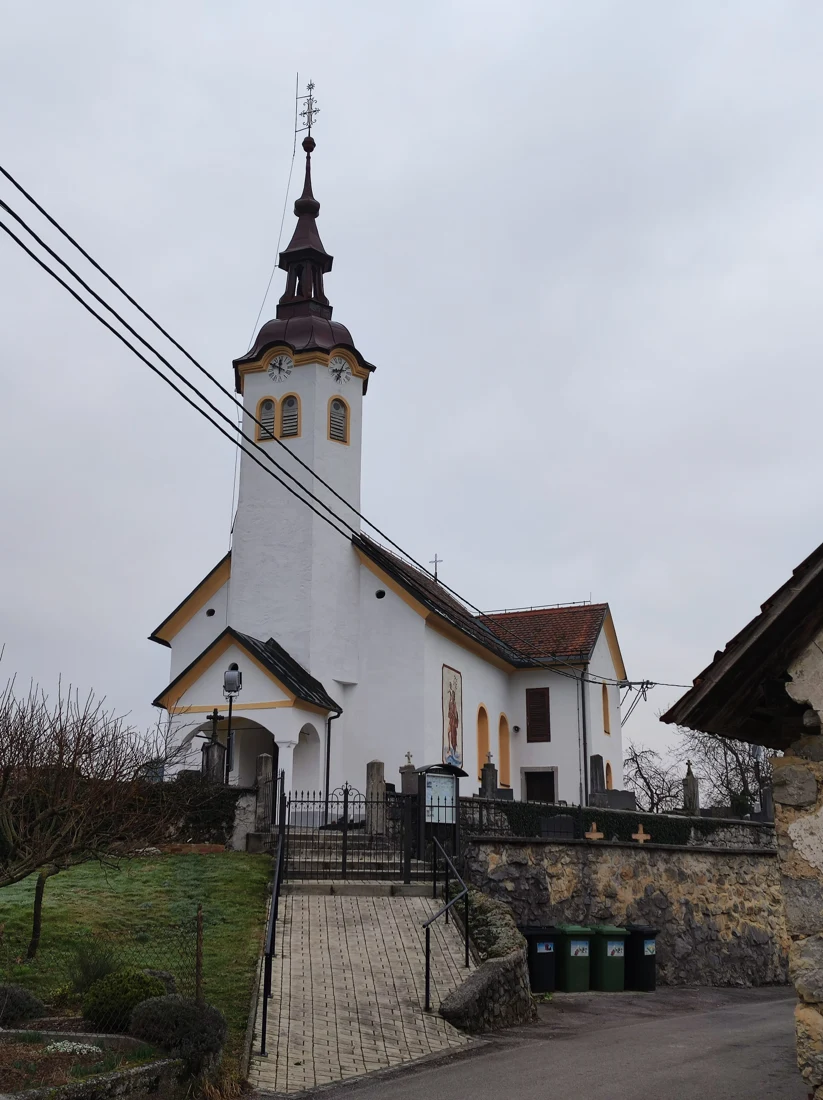Cerkev sv. Lenarta v Stari Vrhniki z vhodno lopo in zvonikom z razgibano streho.