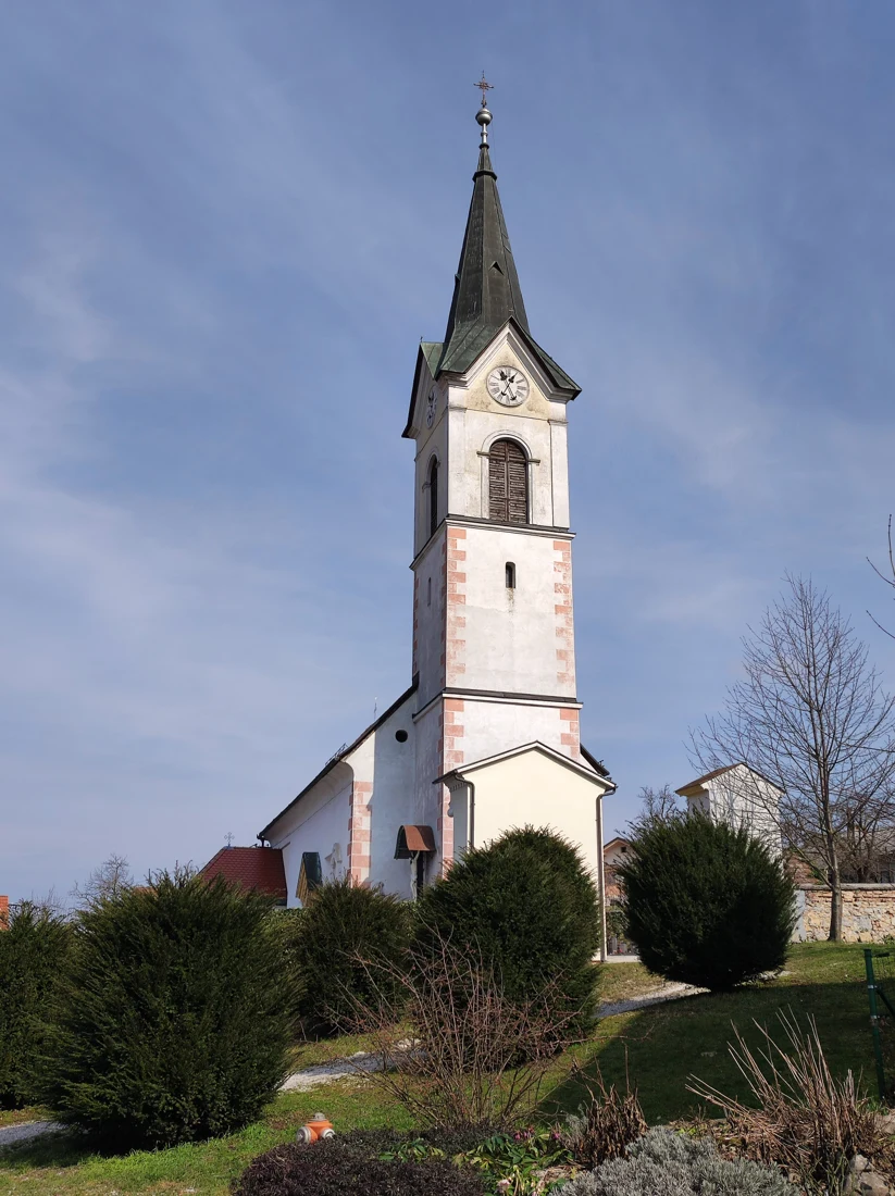 Cerkev sv. Antona Puščavnika na Verdu z visokim zvonikom, urama in vhodno stranjo.