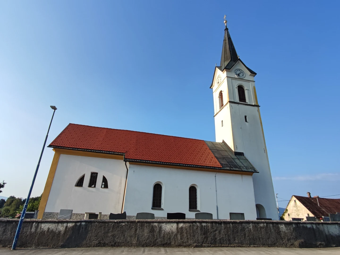 Cerkev sv. Jurija v Veliki Ligojni s pokopališkim obzidjem in vhodnim zvonikom.